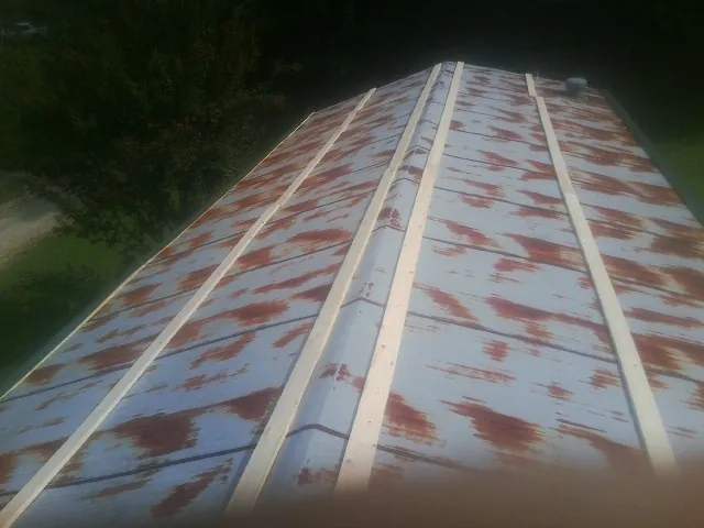 Rusted metal roof panels with new wood purlins before replacement — Storm Damage Roof Repair in Booneville by Roofing Brothers