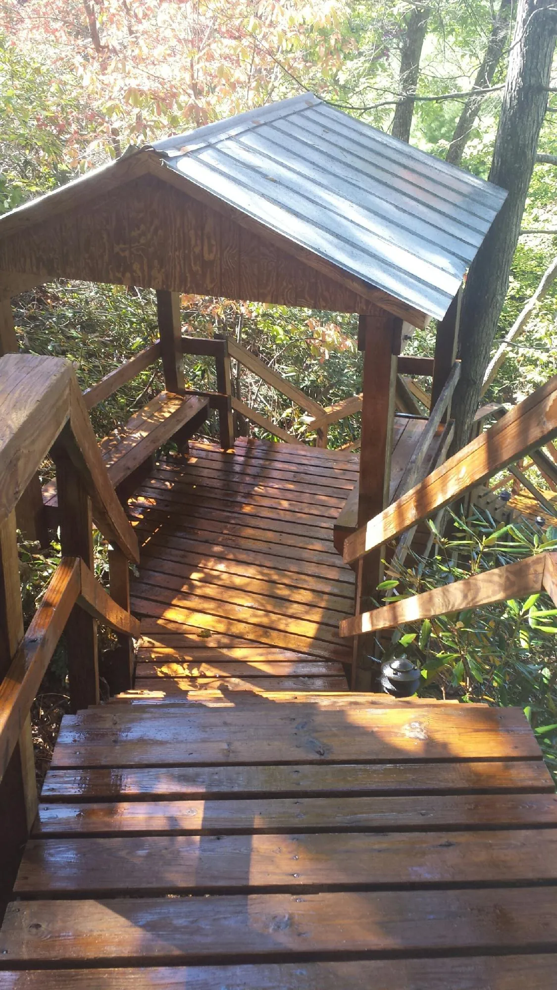 Freshly stained wood walkway and covered shelter with a metal roof in Booneville