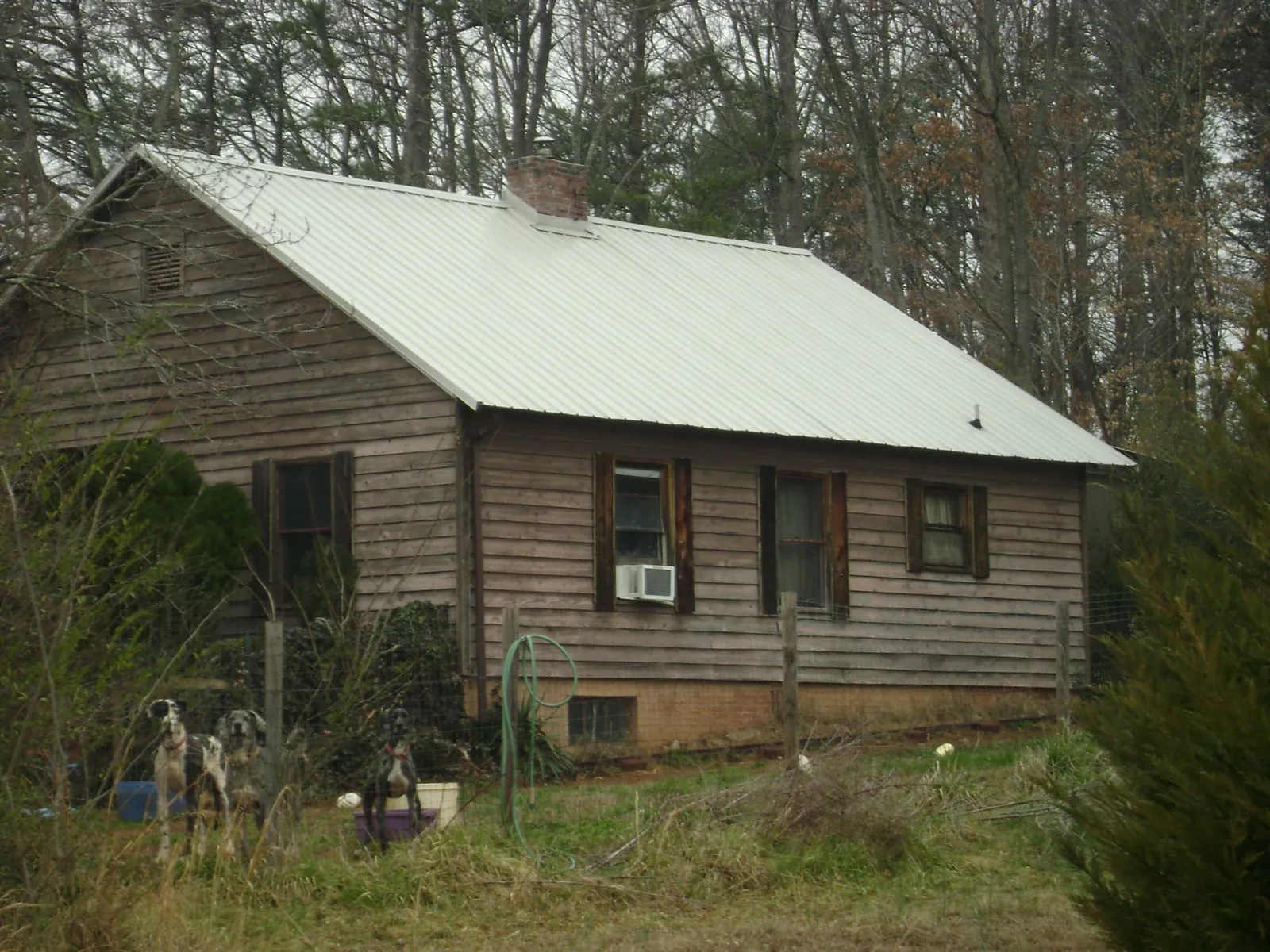 White metal roof on an old wood sided farmhouse, from a Metal Roof Installation job in Booneville